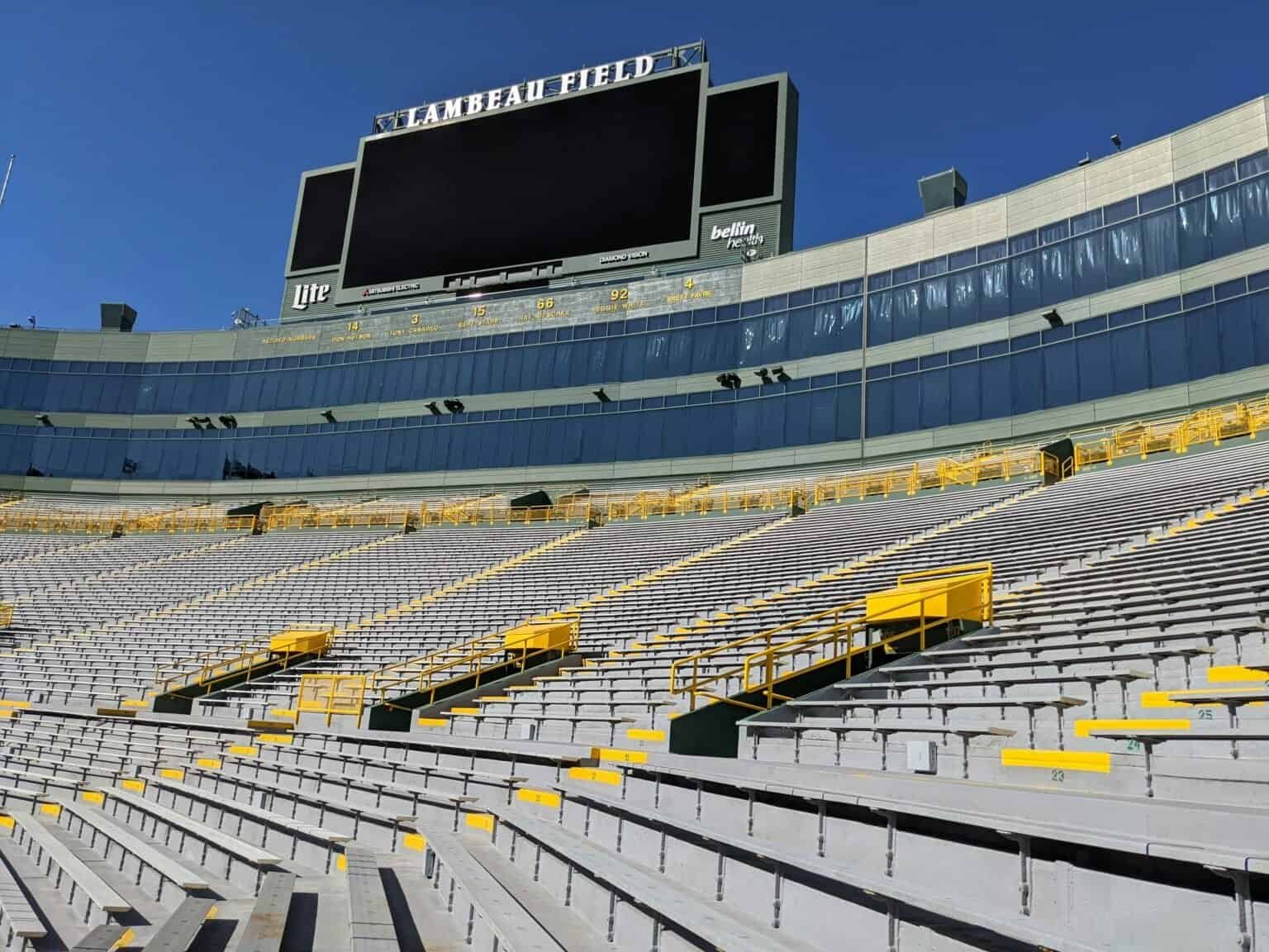 Empty aluminium bench seating rising towards the scoreboard at Lambeau Field, Green Bay