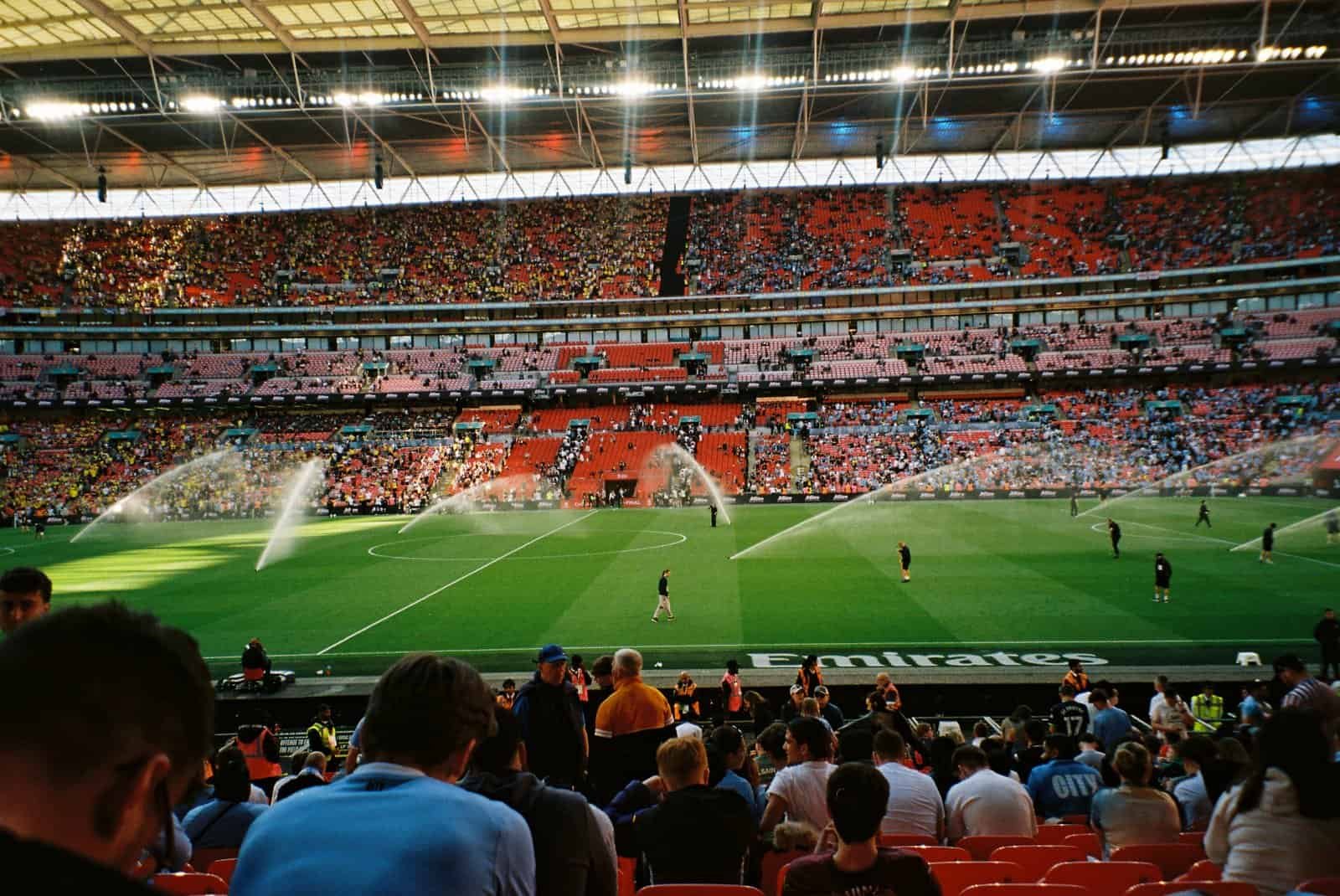 Wembley Stadium filling up before kick-off, the pitch being watered